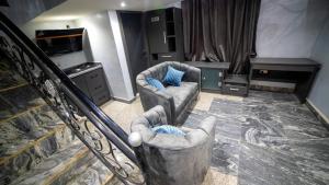 - un salon avec deux chaises et un escalier dans l'établissement Ikeja Airport View, à Lagos