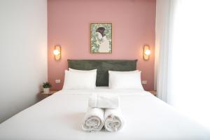 Un dormitorio con una cama blanca con dos toallas encima. en Bruno 55 By Peraia, en Tel Aviv