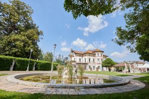 a fountain in front of a large house at Hotel Villa Stucky in Mogliano Veneto