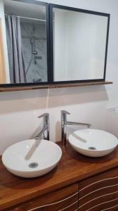 - 2 lavabos sur un comptoir en bois dans la salle de bains dans l'établissement Gîte de la confluence, à Padern