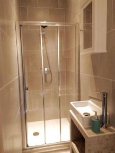 een douche met een glazen deur naast een wastafel bij Spacious villa apartment with mountain view -2 bed in Quillan