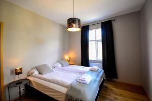 a bedroom with a bed with white sheets and a window at Bjork Guesthouse in Laugarvatn