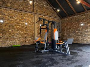 une salle de sport avec des équipements de cardio-training dans un mur de briques dans l'établissement Sosnowy domek w rezerwacie nad Narwią, à Bokiny