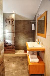 a bathroom with a sink and a lighthouse on the wall at Palacete Maria Rosa in Baños de la Encina