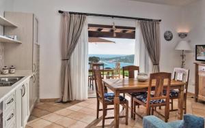een keuken en eetkamer met een tafel en stoelen bij Vistamare Grande Pevero in Porto Cervo