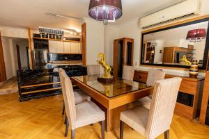 a dining room with a glass table and chairs at Modern Luxe Oak Orchid 3BR Apt W-Free WiFi &Parking in Cairo