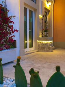 una porta d'ingresso di una casa con cactus nel cortile di L'Antico Pozzo a Pozzallo