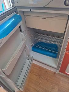 een open koelkast met een blauw item erin bij Camping car à 3 minutes du parc Pairi Daiza in Brugelette