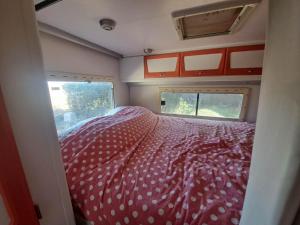 una camera da letto in un camper con un letto e una finestra di Camping car à 3 minutes du parc Pairi Daiza a Brugelette