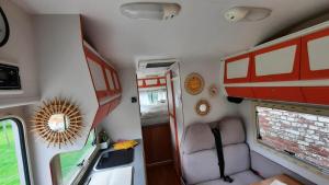 einen Innenblick auf einen Wohnwagen mit einem Stuhl und einem Spiegel in der Unterkunft Camping car à 3 minutes du parc Pairi Daiza in Brugelette