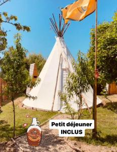 Camping Syl-Vallée Western Village في Bouglon: علامة علي خيمة مع زجاجة من الهند بجوار علامة
