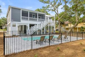 a house with a swimming pool with chairs at The Jungle House in Edisto Island