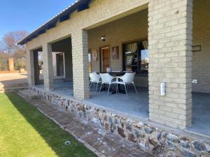 un patio con sillas y una mesa en un edificio en Zacks Country Stay Self-catering, en Krugersdorp