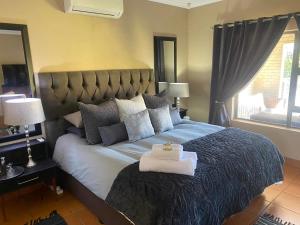 - une chambre avec un grand lit et une serviette dans l'établissement Zacks Country Stay Self-catering, à Krugersdorp