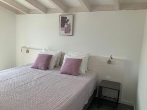 a bedroom with a bed with two purple pillows at Quinta da Ema 
