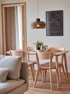 Kivikatu Apartment في روفانييمي: غرفة طعام مع طاولة وكراسي وأريكة