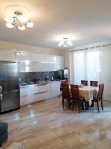 a kitchen with a table and chairs and a refrigerator at Holiday Center Apartment in Shkodër