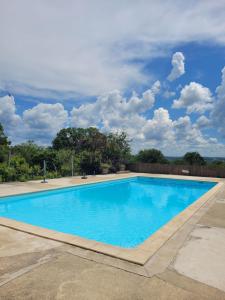 una gran piscina azul con un cielo nublado en L'Oasienne, en Lissac et Mouret