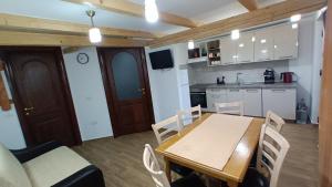 eine Küche und ein Esszimmer mit einem Holztisch und Stühlen in der Unterkunft Chalet Alina in Borşa