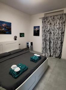 una camera da letto con un letto con due asciugamani sopra di City View! Panoramic Apartment overlooking La Spezia a La Spezia