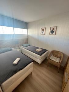 a bedroom with two beds and a chair in it at TOP Benalmadena in Benalmádena