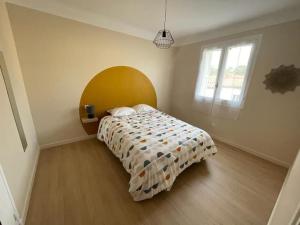 a bedroom with a bed with a comforter and a window at LG RITE Appartement avec jardin in Prades