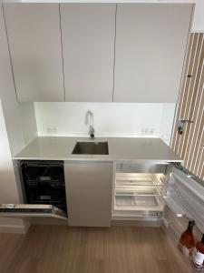 a kitchen with a sink and an empty refrigerator at TOP Benalmadena in Benalmádena