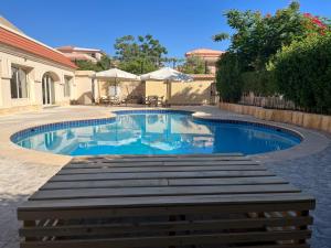 a swimming pool with blue water in a yard at Rihana Studio & pool in Borg El Arab