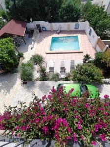um carro estacionado ao lado de uma piscina com flores em Villa Olma em Trogir