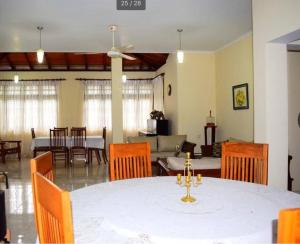 une salle à manger avec une table et des chaises blanches dans l'établissement Reverie Hill Bungalow, Kandy, à Kandy