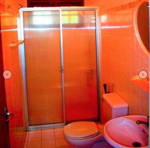 a bathroom with a shower and a toilet and a sink at Reverie Hill Bungalow, Kandy in Kandy