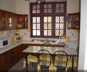a kitchen with a table and chairs and a microwave at Reverie Hill Bungalow, Kandy in Kandy