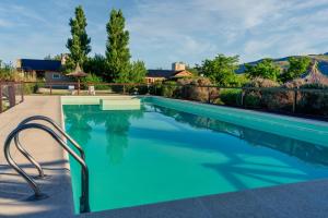 a swimming pool with blue water in a yard at Los Llantenes in San Andres de las Sierras