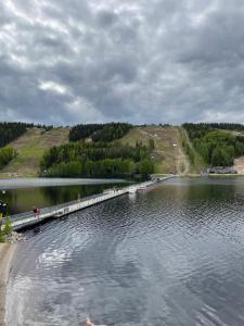 a bridge over a lake with a group of people on it at Spa Hotel RED in Tahkovuori