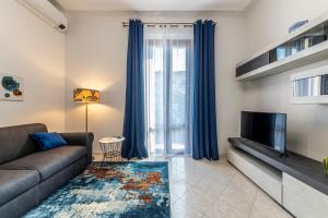 uma sala de estar com um sofá e uma televisão em Biloba - Boutique Apartment em Milão
