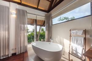 a bathroom with a large tub and a large window at L'Osteria Luxe Beachfront B&B in General Luna