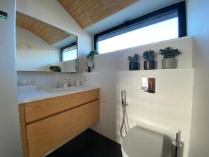 un bagno con lavandino, water e finestra di Seaside Rendezvous a Kalana