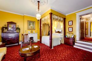 維克斯堡的住宿－Anchuca Historic Mansion & Inn，一间大卧室,配有一张床铺和一张桌子