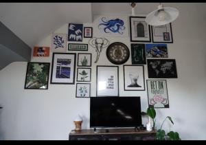 una pared con cuadros y una TV en la pared en Penthouse suite, Victoria Apartments, en Prestatyn