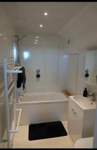 a white bathroom with a tub and a toilet at Penthouse suite, Victoria Apartments in Prestatyn