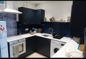 a kitchen with a sink and a washing machine at Penthouse suite, Victoria Apartments in Prestatyn