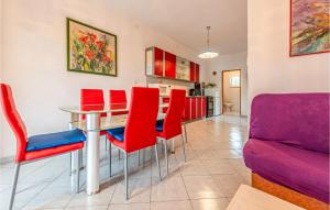 a kitchen and dining room with red chairs and a table at Two-Bedroom Apartment In Vir in Vir
