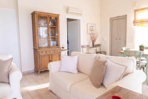 a living room with a white couch and a table at Kos Secret Villa with private pool in (( Kermetés ))