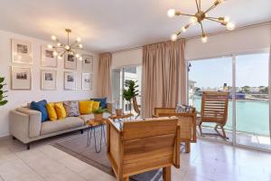 a living room with a couch and a table at Waterfront views of Historic Zona Colonial in Riviera Colonial in Calero