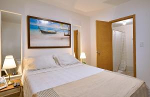 ein Schlafzimmer mit einem Bett mit einem Bild an der Wand in der Unterkunft Waterfront views of Historic Zona Colonial in Riviera Colonial in Calero