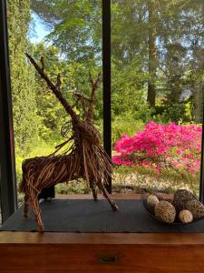 une sculpture d'un arbre sur une table à côté d'une fenêtre dans l'établissement Vakantiehuis Bos en Hei Veluwe, à Epe