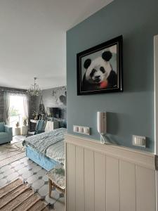 una camera da letto con una foto di panda a parete di Apartament na Wzgórzu Miętowy a Łańcut
