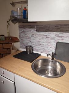 a kitchen counter with a sink and a brick wall at Casa da vila de Caria in Caria