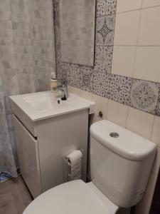 a bathroom with a white toilet and a sink at Casa da vila de Caria in Caria