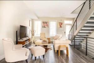 a living room with white furniture and a staircase at Burj Arab Luxury in Tower Grove